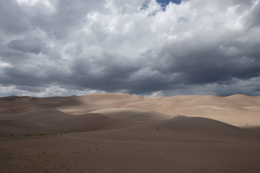 Sand Dunes with dark clouds that shadows half the dunes.